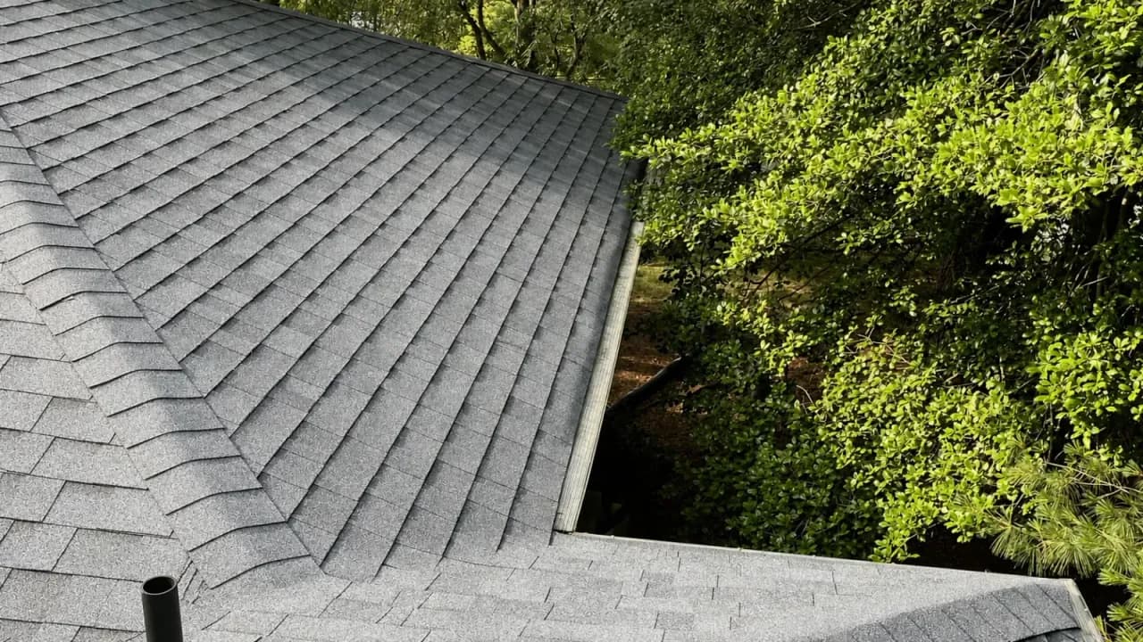 Photo of the same roof section after shingle repair, with new asphalt shingles installed in clean, even rows